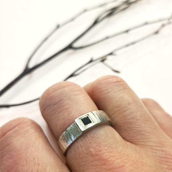 Bague contemporaine en argent texturé et diamant noir taille princesse. Créée et fabriquée à l'atelier à Lyon