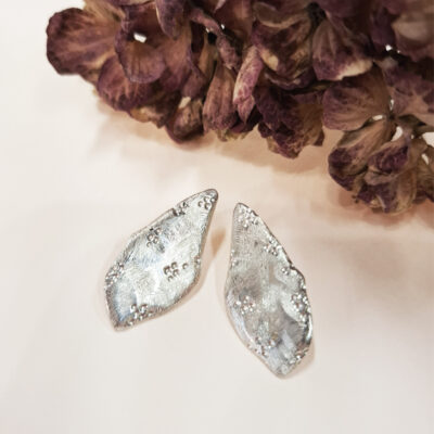 Sophie Mouleyre, bijoutière lyonnaise, réalise ces boucles d'oreilles texturées et raffinées en argent 925 à la main.